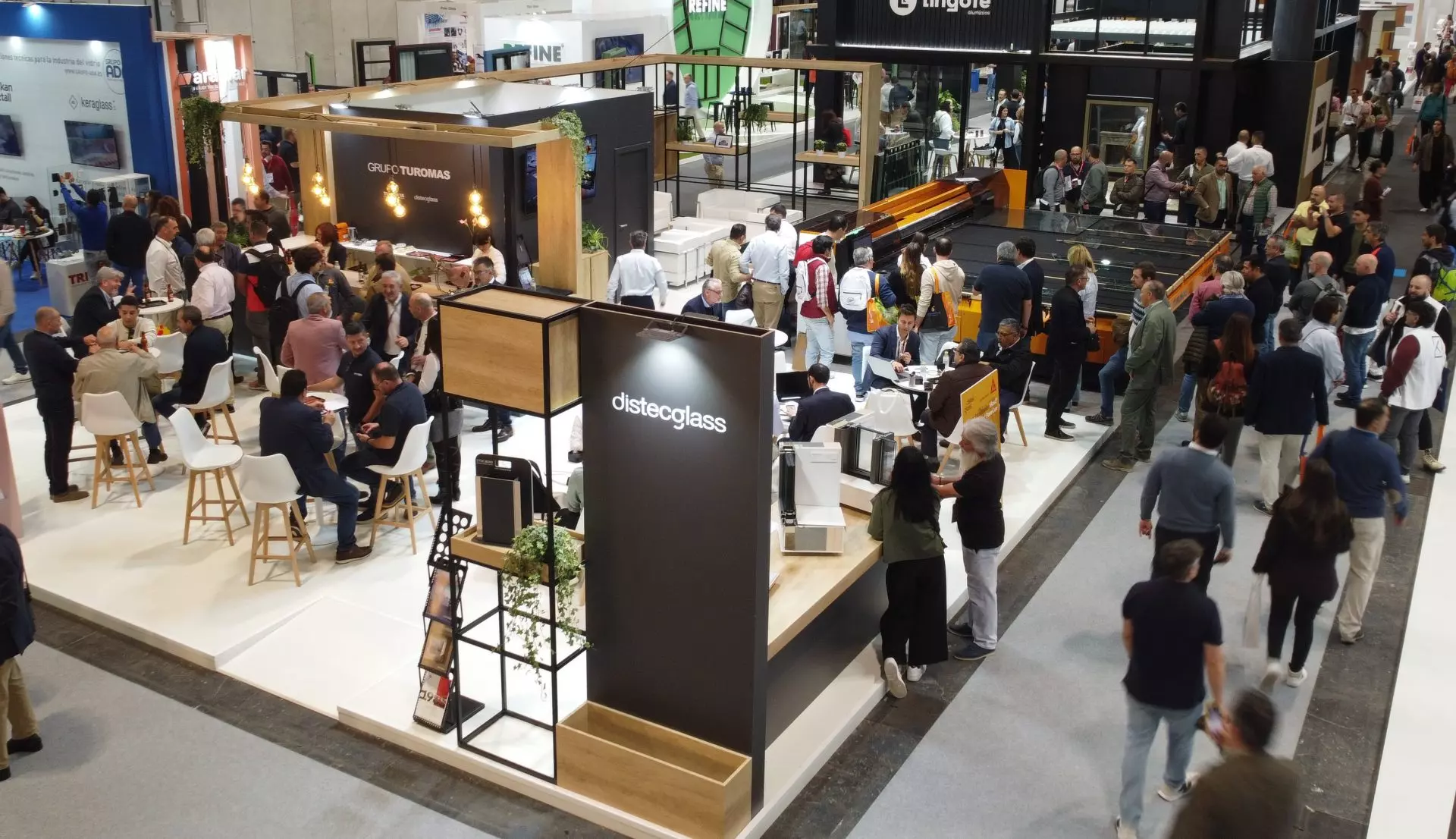 Vista aérea del stand del Grupo TUROMAS con maquinaria y visitantes